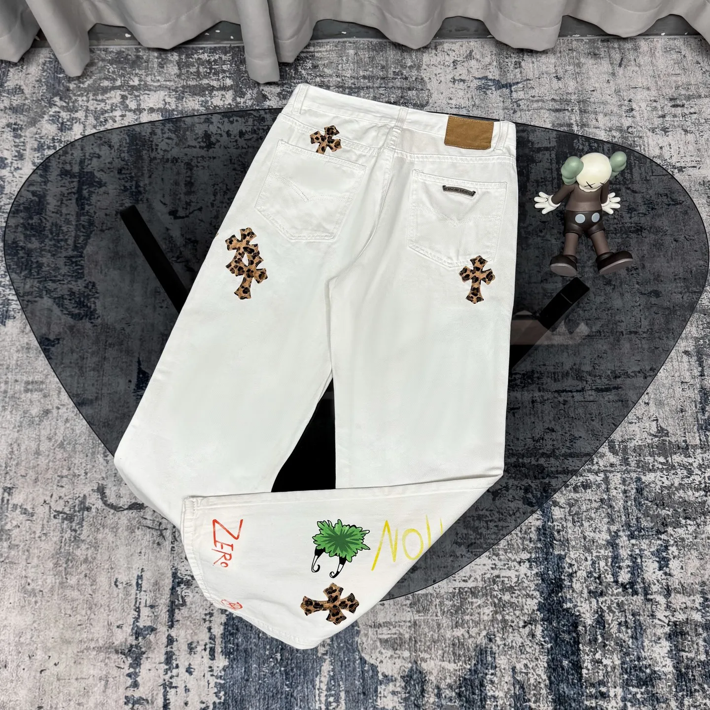 P250 Chrome Hearts｜CH Chrome Hearts 25SS high street jeans with leopard print and vintage graffiti paintings. Chrome Hearts are the most popular pants in color. Made of beaded canvas fabric, heavy washing makes the upper body of the fabric more textured and the pants are tall and straight! The three-dimensional cutting of the whole trousers is a masterpiece! The hardware is customized by zp. The beaded canvas fabric is thick and soft after being washed. It has good breathability. Customized small leather label. Unique design. The details are simple and elegant, and the workmanship is exquisite. The whole trousers are neatly routed and the details are in place! It’s so cool that both men and women can easily control the genderless trend! Color: White Size: 28 30 32 34